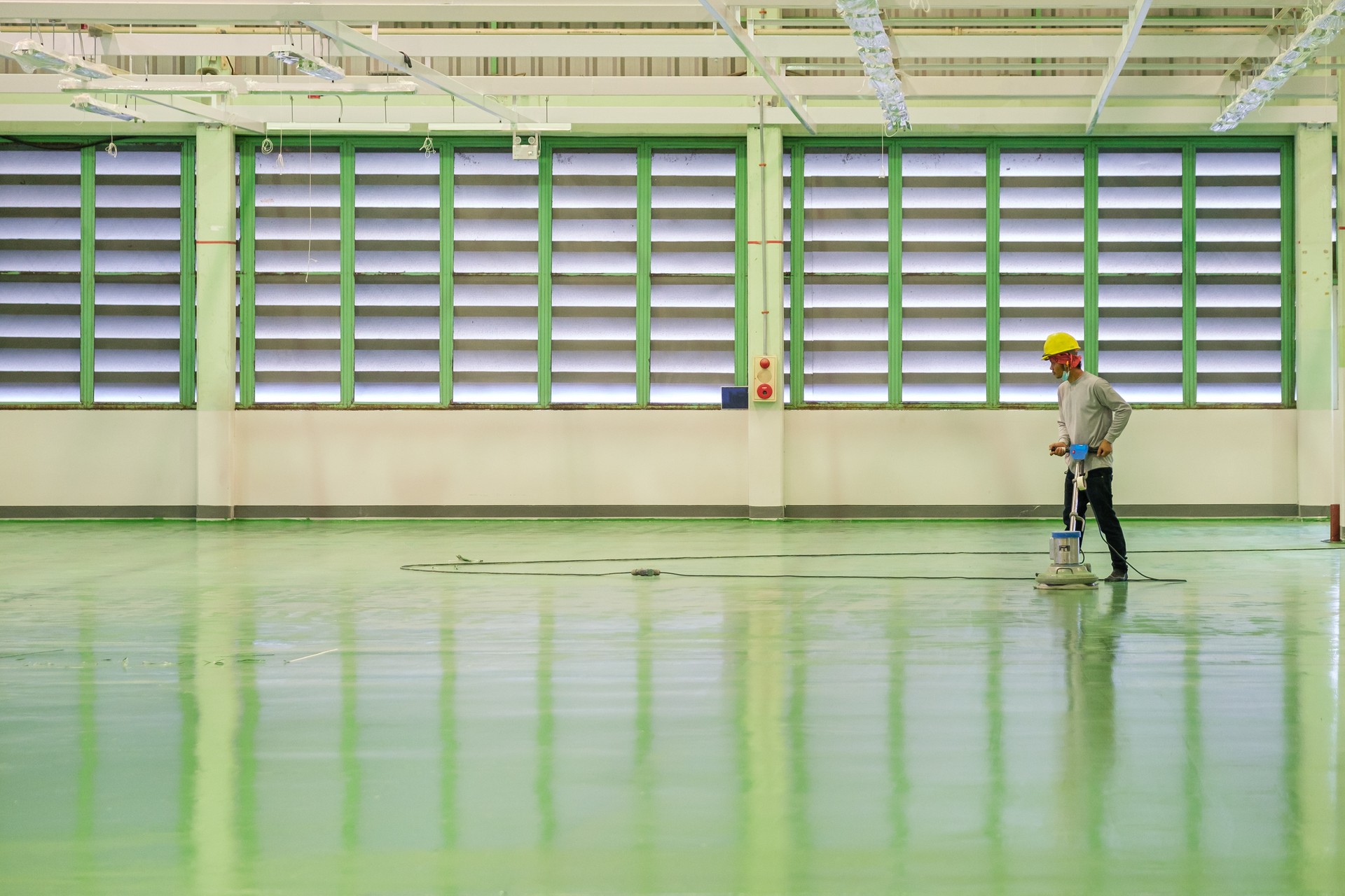 Construction worker using floor grinding machine polishing floor before epoxy primer Self-leveling method of epoxy floor finishing work